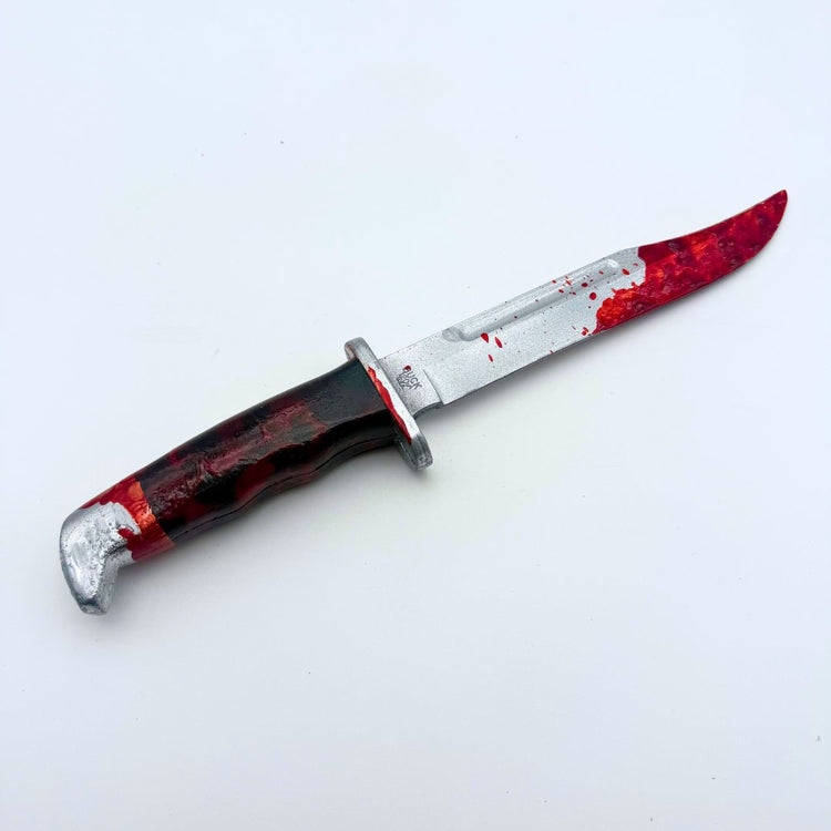 Right side view 12 inch plastic survival hunting knife inspired by the 120 Buck design from the Scream horror movie franchise, featuring a silver blade and black handle, blood on knife tip and handle, designed for cosplay or display