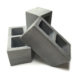 Group view of three realistic flexible foam prop cinder blocks with a gray stone color and texture, designed for safe use in stunts, theater, or film