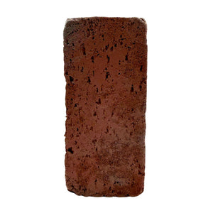 A single rectangular red clay brick with a rough, porous texture, centered on a plain white background.