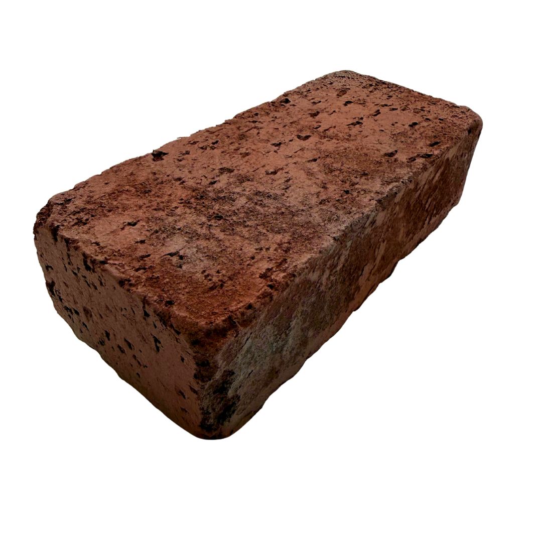 A single rough red clay brick with a textured surface and dark speckles, isolated on a white background.