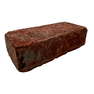 A single rectangular red clay brick with a rough, weathered texture, isolated on a solid white background.
