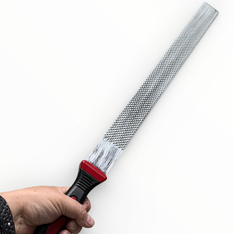 Hand holding a diamond rasp tool with a red handle on a white background