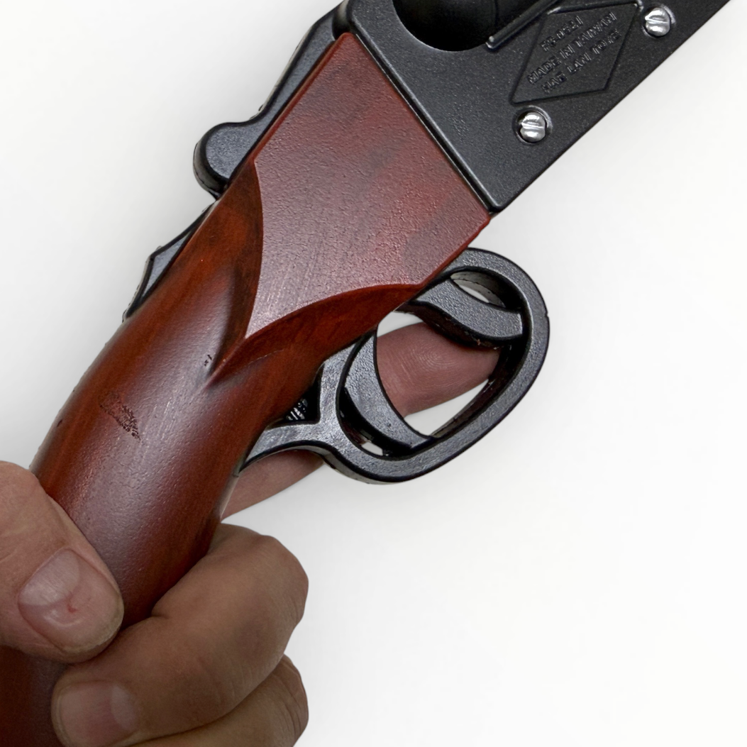 Close-up of a hand holding a revolver with a wooden grip on a white background