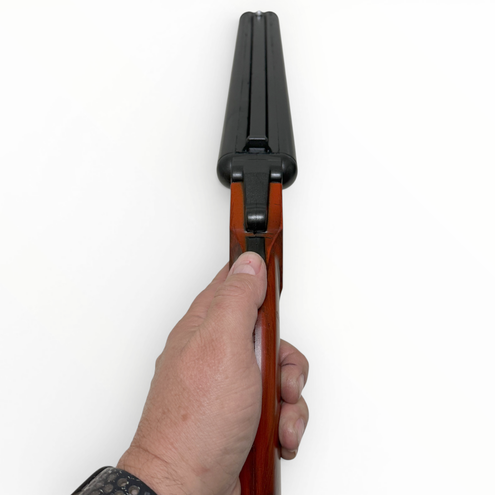 Hand holding a rifle with wooden stock and black metal parts on a white background