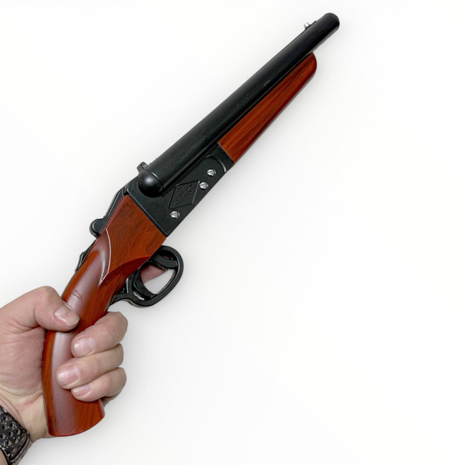 Hand holding a rifle with wooden stock and black metal parts on a white background