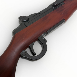 Wooden rifle with black metal components on a white background