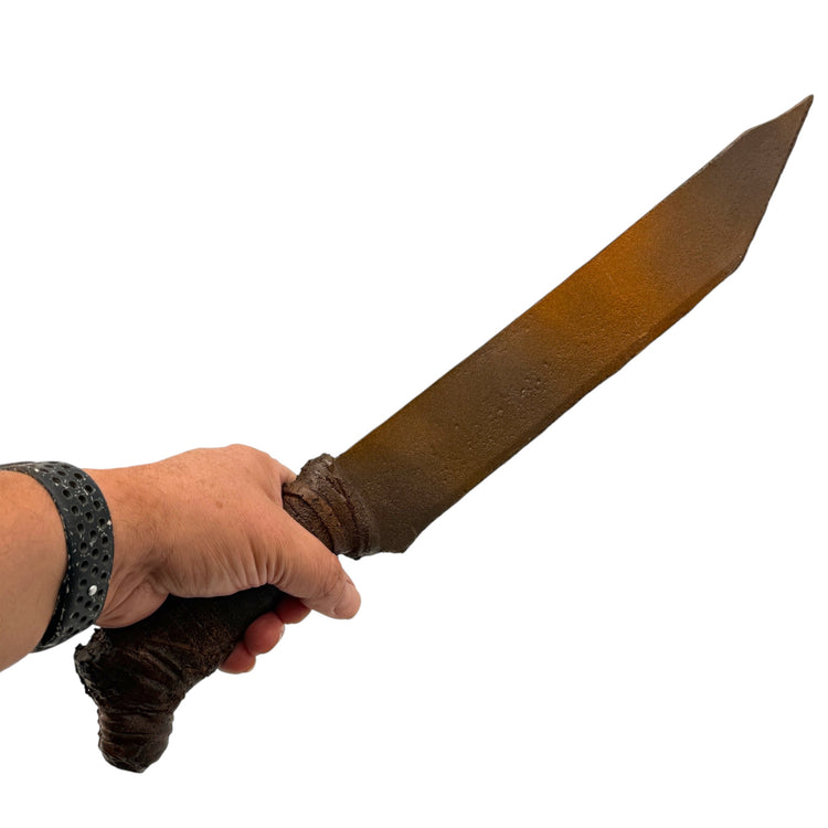 A hand holding a large, weathered fantasy sword with a dark brown textured handle and a rusty bronze blade, shown against a plain white background.