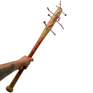 hand holding Baseball bat with bloody nails sticking out