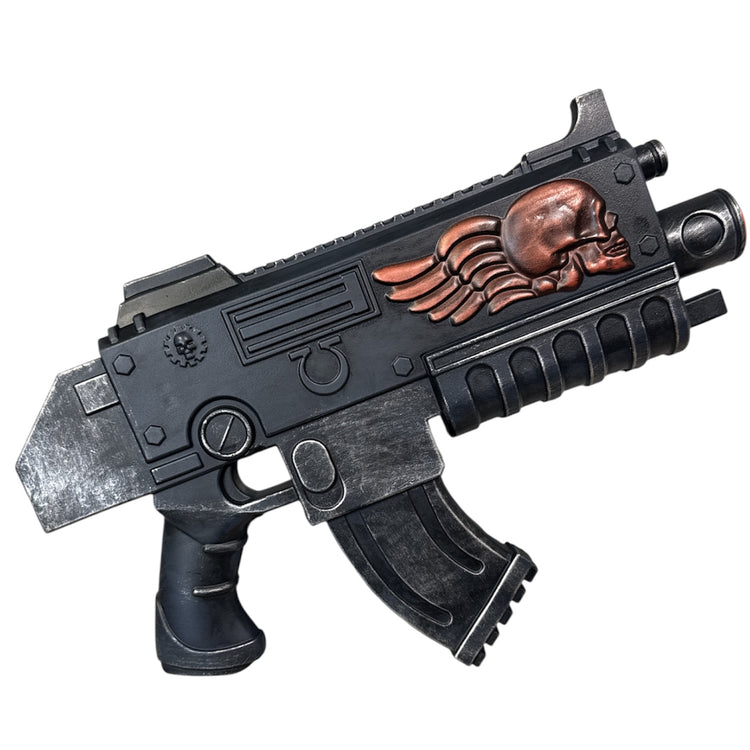 Foam Space Marine Bolter Prop Gun, a sci-fi styled weapon with a dark metal finish, features a copper skull emblem, ergonomic grips, and a chunky, industrial design.