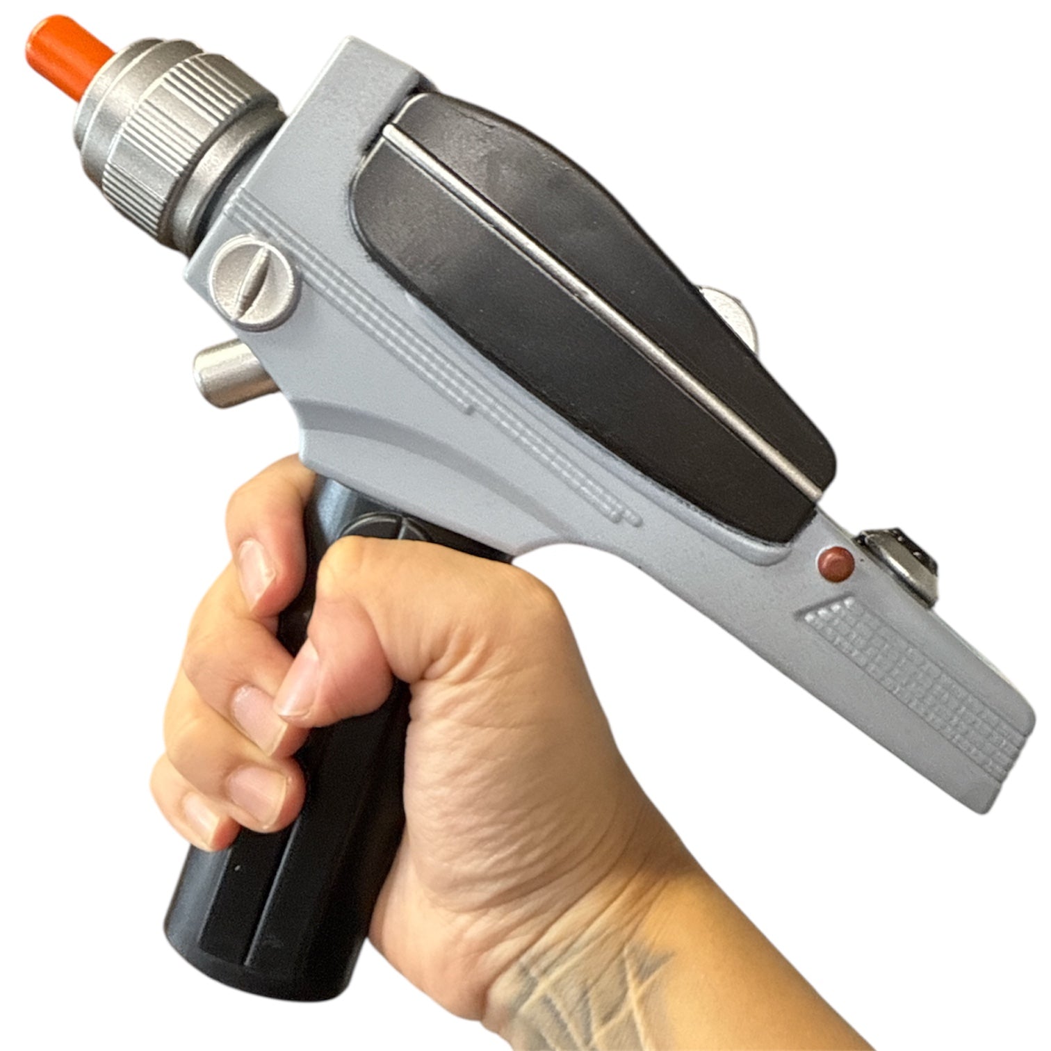 Hand holds Star Trek Phaser toy, featuring a grey and black sci-fi design with orange safety tip, trigger handle, and futuristic details.