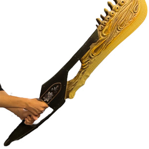 Person holding Foam Giant Monster Jawblade Sword Prop, featuring a textured golden blade with flowing patterns and a dark hilt with decorative inlays.