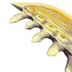 Foam Giant Monster Jawblade Sword Prop features a yellow-bronze-toned curved strip with fluted surface and conical knobs, suggesting an ornate decorative element.