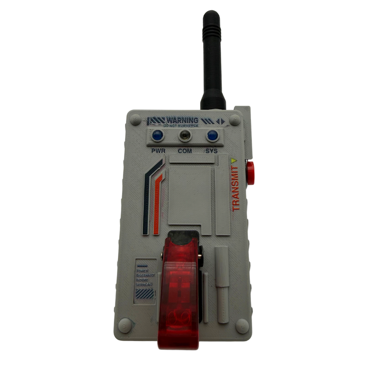A gray industrial handheld transmitter device with a black antenna, blue indicator lights, a red emergency stop button, and a red translucent front cover, shown on a plain white background.