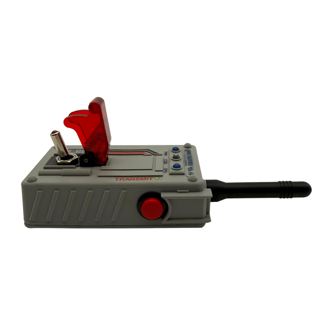 A gray handheld electronic device with a red flip-up cover, a red circular button, a black antenna, and a small metal contact point, shown on a plain white background.
