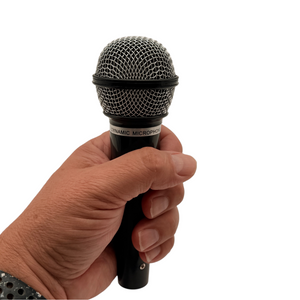 Handheld microphone prop shown in a hand for scale